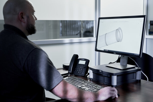 Schiedel Mitarbeiter arbeitet am PC mit der BIM Bibliothek und sieht sich gerade eine Zeichnung eines Edelstahl Rohres an