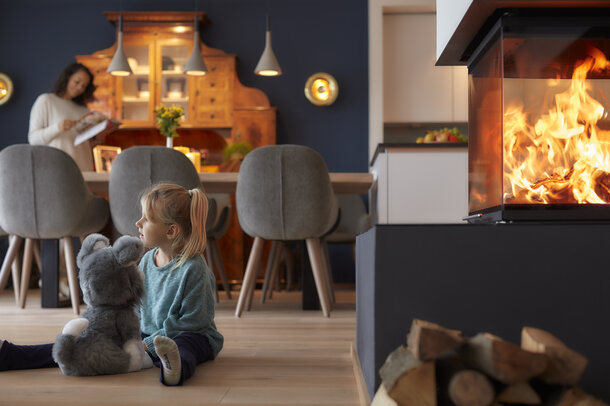 Child playing with a cuddly toy in front of the stove