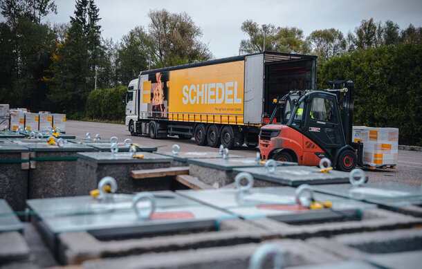 Schiedel lastbil lastas av en gaffeltruck.