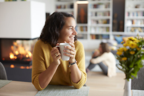 Woman with tea in front of the stove