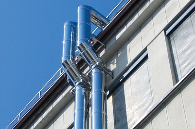 Zwei Schiedel ICS Abgassysteme an der Außenfassade eines Gebäudes