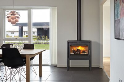 Frittstående Meteor peisovn skaper en varm og innbydende atmosfære i rommet.