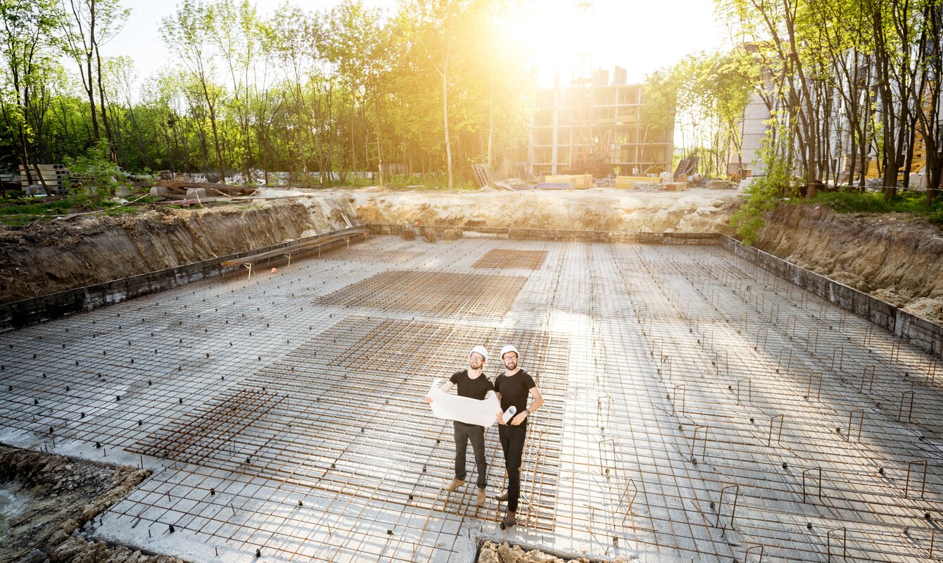 Professionals on the building site on a foundation with probation poles